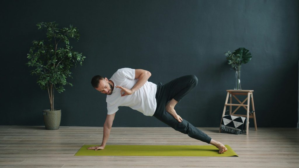 Man practicing yoga on a mat indoors