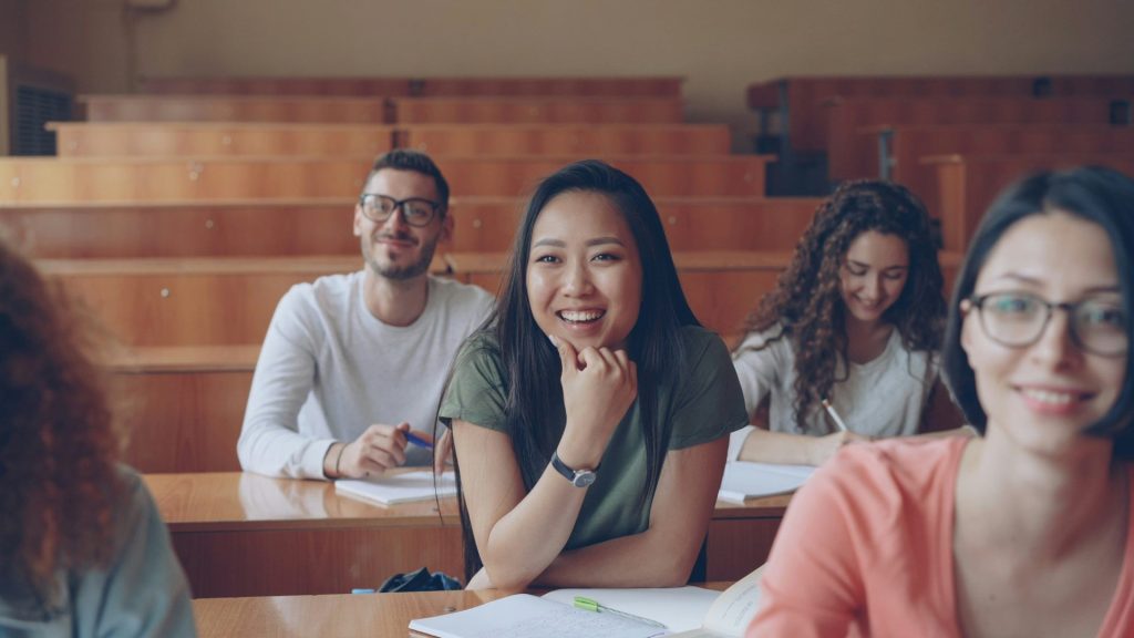 Students smiling in a lecture hall classroom